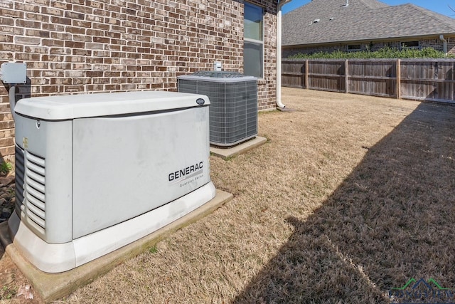 details featuring central air condition unit, a power unit, and fence