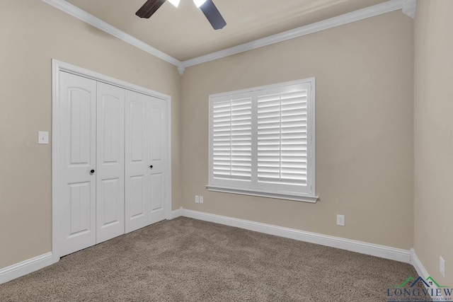 unfurnished bedroom featuring a ceiling fan, baseboards, a closet, crown molding, and carpet flooring