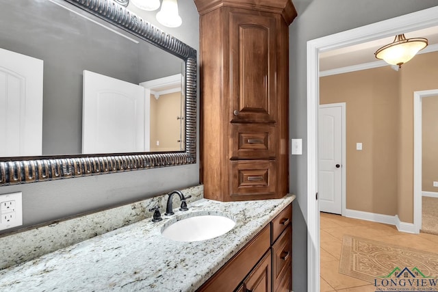 bathroom featuring tile patterned flooring, vanity, crown molding, and baseboards