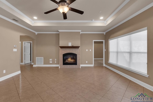 unfurnished living room with visible vents, ceiling fan, baseboards, and a tray ceiling