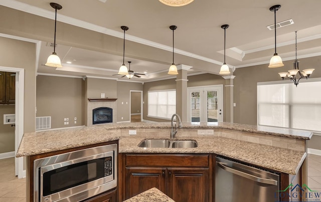 kitchen with visible vents, a tray ceiling, a sink, stainless steel appliances, and ceiling fan with notable chandelier