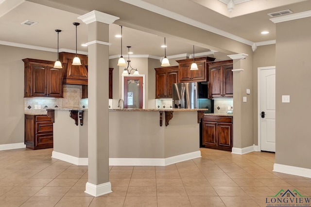 kitchen with a kitchen breakfast bar, visible vents, stainless steel refrigerator with ice dispenser, and baseboards