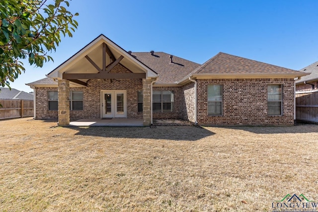 back of property with fence, brick siding, and roof with shingles