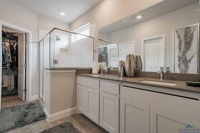 bathroom with vanity, an enclosed shower, and hardwood / wood-style flooring