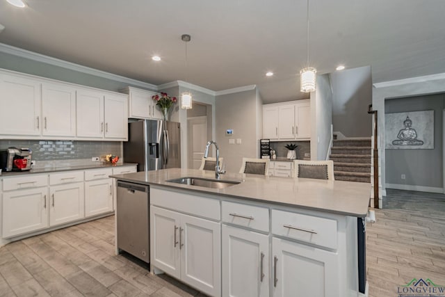 kitchen featuring white cabinets, hanging light fixtures, sink, and appliances with stainless steel finishes