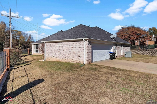 view of side of home featuring central AC, a yard, and a garage