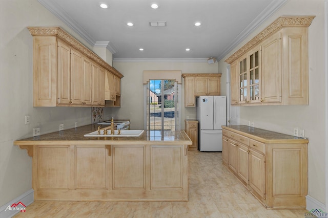 kitchen featuring white refrigerator, kitchen peninsula, a breakfast bar area, and light brown cabinets