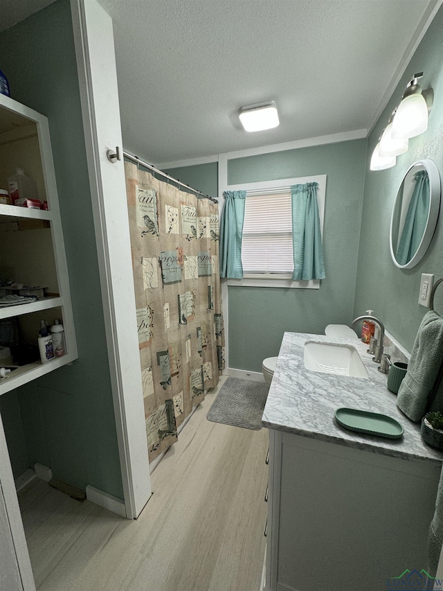 bathroom with walk in shower, toilet, wood-type flooring, a textured ceiling, and vanity