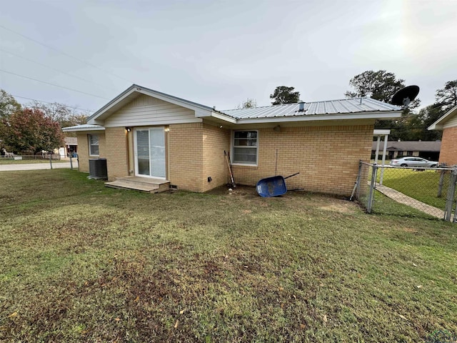 back of house featuring a yard and central air condition unit