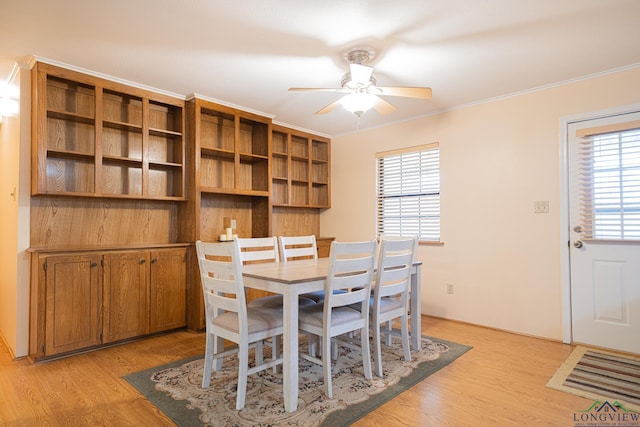 dining area featuring crown molding, ceiling fan, and light wood-type flooring