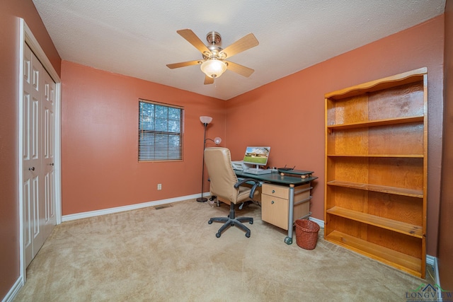 carpeted office with ceiling fan and a textured ceiling