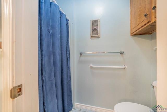 bathroom with tile patterned floors, toilet, and curtained shower