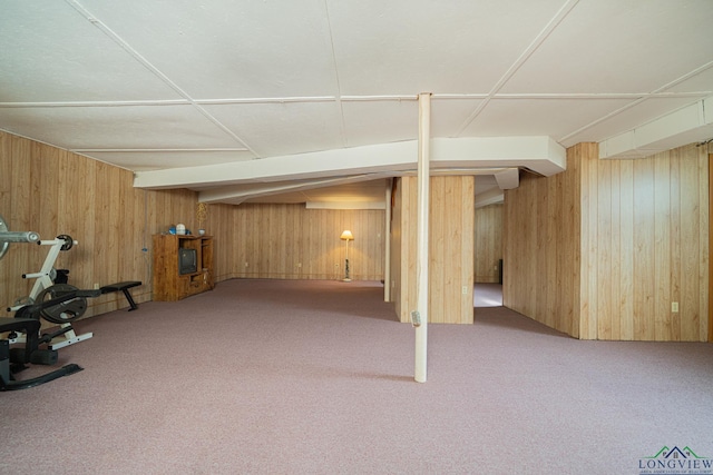 basement featuring wooden walls and carpet flooring