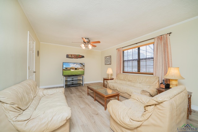 living room featuring ceiling fan, ornamental molding, a textured ceiling, and light wood-type flooring