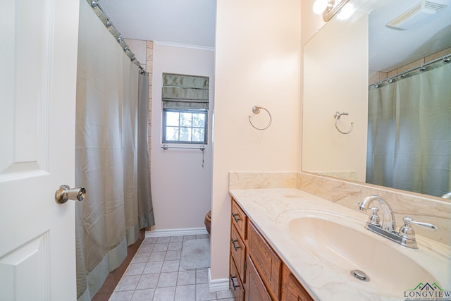 bathroom featuring tile patterned flooring, vanity, and ornamental molding