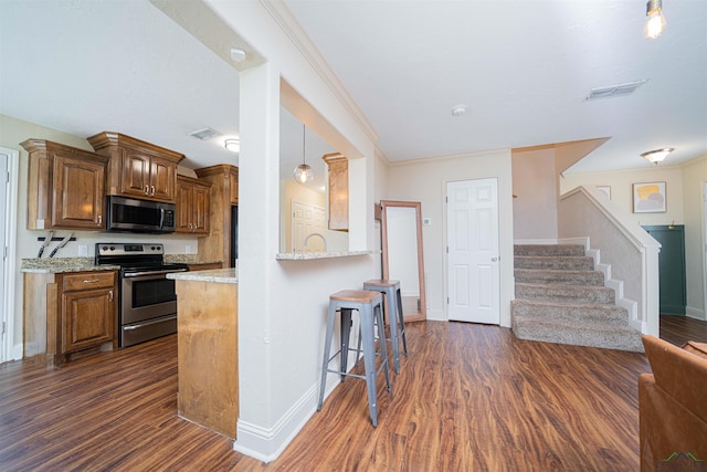 1700 Van Zandt Ave, Marshall, TX 75670 - kitchen with appliances with stainless steel finishes, dark wood-style floors, a kitchen bar, brown cabinets, and crown molding
