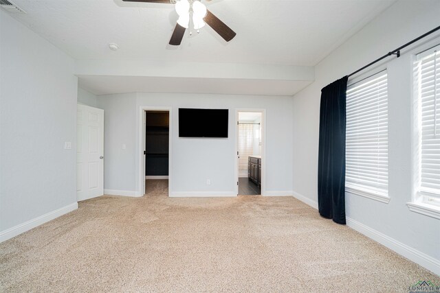1700 Van Zandt Ave, Marshall, TX 75670 - unfurnished bedroom with light colored carpet, a spacious closet, a ceiling fan, and ensuite bath