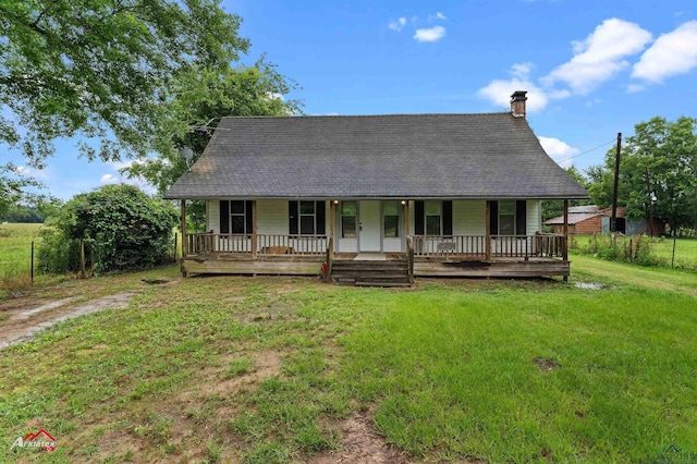 154 County Rd 117, Carthage, TX 75633 - view of front of property with covered porch, a chimney, a front yard, and a shingled roof