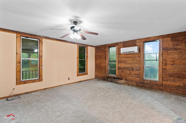 154 County Rd 117, Carthage, TX 75633 - carpeted empty room featuring an AC wall unit, a ceiling fan, and wood walls