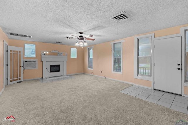 154 County Rd 117, Carthage, TX 75633 - unfurnished living room with carpet flooring, ceiling fan, a wall mounted AC, a glass covered fireplace, and tile patterned flooring