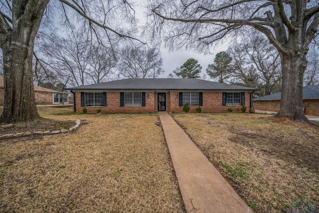 single story home featuring a front yard and brick siding