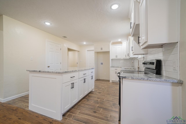 kitchen featuring dark wood-type flooring, white cabinets, backsplash, and a center island