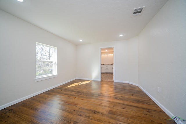 spare room featuring recessed lighting, wood finished floors, visible vents, and baseboards