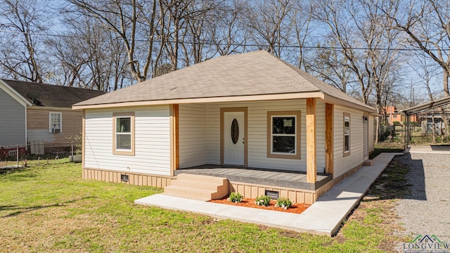 view of front of property featuring a porch, roof with shingles, a front lawn, and fence