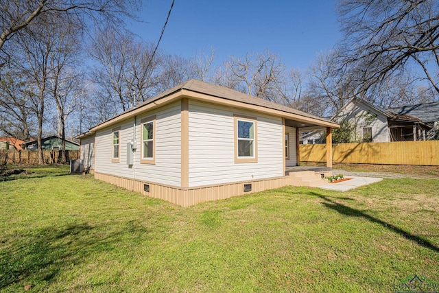 view of side of home featuring crawl space, central air condition unit, a lawn, and fence