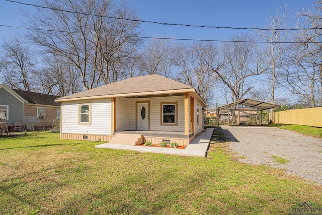 view of front of property with driveway, fence, a front yard, crawl space, and a carport