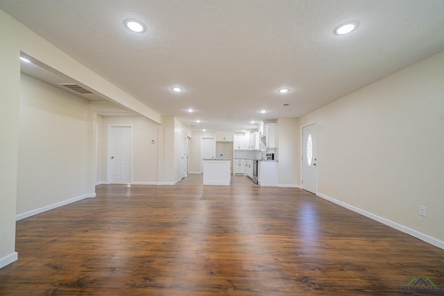 unfurnished living room with recessed lighting, visible vents, baseboards, and dark wood-style flooring