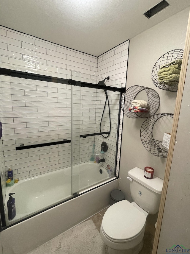 bathroom featuring tile patterned floors, toilet, and combined bath / shower with glass door