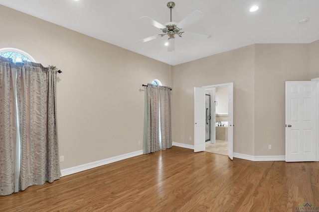 unfurnished bedroom featuring wood-type flooring, ensuite bathroom, and ceiling fan