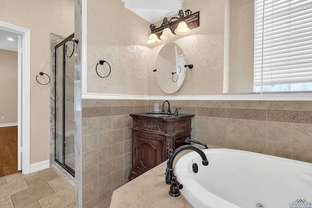 bathroom with vanity and shower with separate bathtub