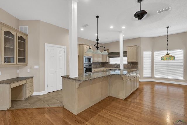 kitchen featuring backsplash, decorative light fixtures, dark stone countertops, and stainless steel appliances