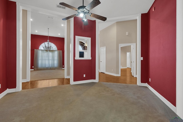 interior space with ceiling fan with notable chandelier and crown molding