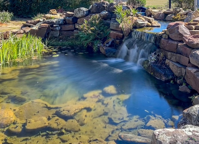 view of swimming pool with a garden pond