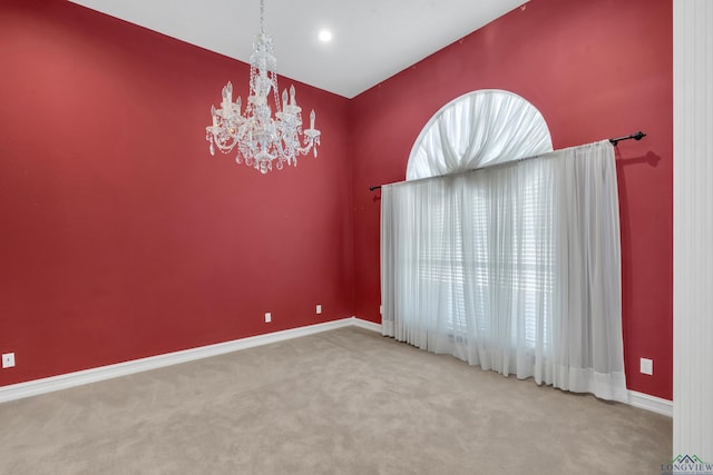 empty room with carpet flooring and a notable chandelier