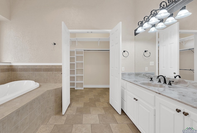 bathroom featuring vanity and tiled tub