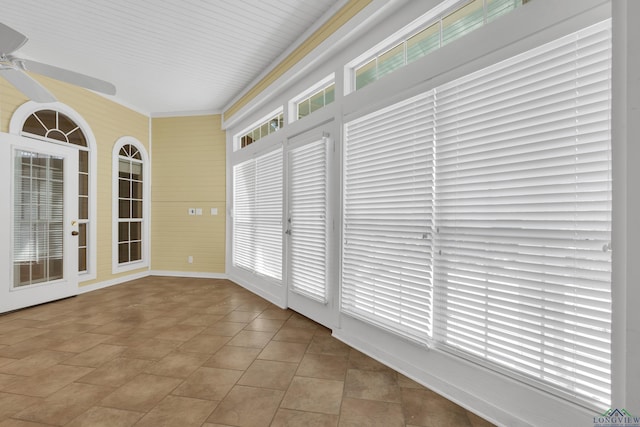 unfurnished sunroom with ceiling fan and a healthy amount of sunlight