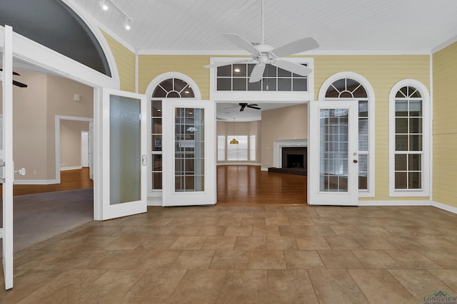 interior space with french doors, a towering ceiling, and ceiling fan