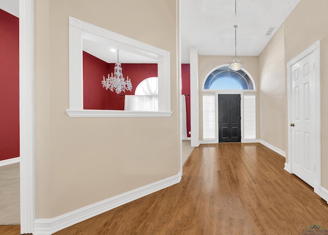 entrance foyer featuring wood-type flooring and a notable chandelier