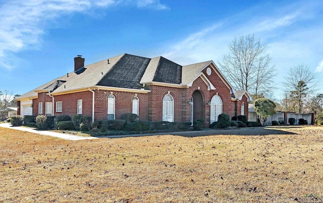 view of side of home with a garage and a lawn