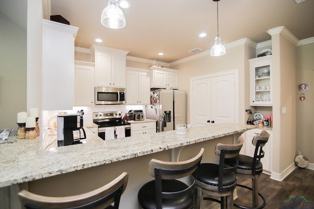 2131 Page Creek Trl, Longview, TX 75601 - kitchen featuring appliances with stainless steel finishes, a peninsula, a breakfast bar, white cabinetry, and dark wood-style floors