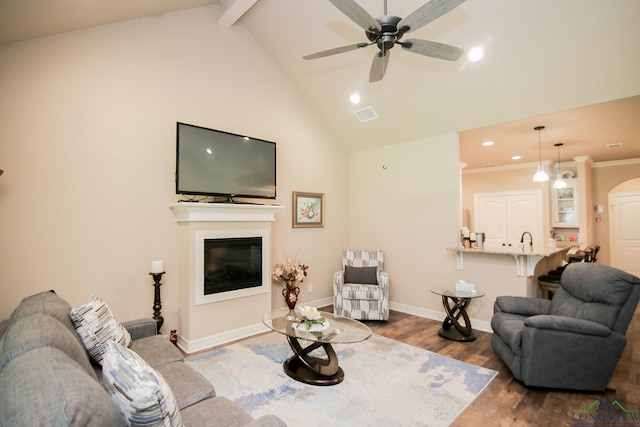 2131 Page Creek Trl, Longview, TX 75601 - living area featuring wood finished floors, ceiling fan, high vaulted ceiling, a glass covered fireplace, and beam ceiling