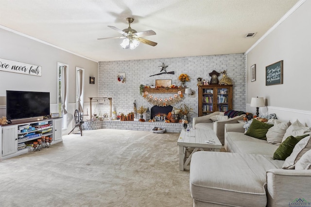 living room with crown molding, a brick fireplace, ceiling fan, a textured ceiling, and carpet floors