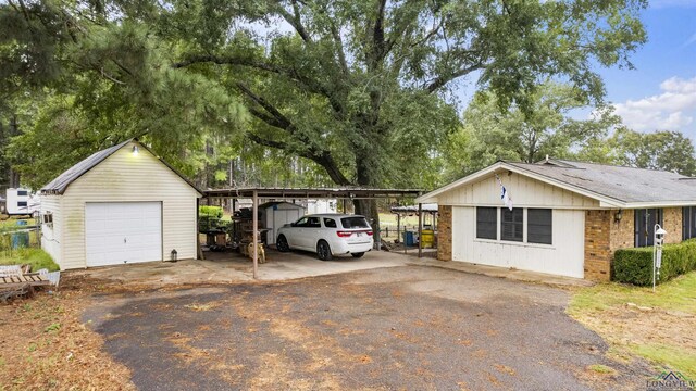 view of front of home with a garage, an outdoor structure, and a carport