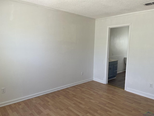 empty room with a textured ceiling and dark hardwood / wood-style flooring