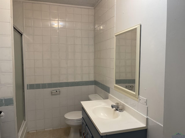 bathroom with vanity, a textured ceiling, tile walls, tile patterned flooring, and toilet