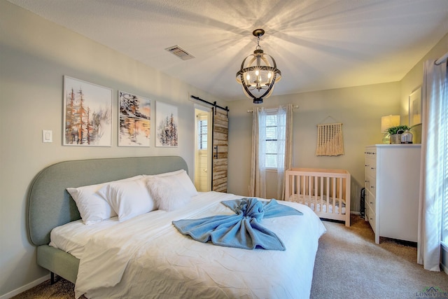 carpeted bedroom featuring visible vents, a notable chandelier, baseboards, and a barn door